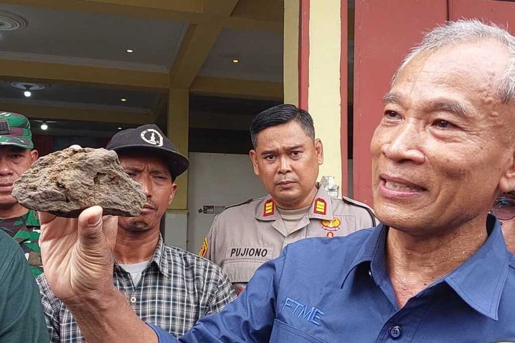 Prof Basuki Rahmad saat menunjukan batuan berwarna gelap yang diambil sebagai sampel (Sumber: kompas.com)